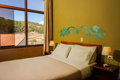 a bedroom with a bed and a window with a view at Wild Rover Cusco in Cusco