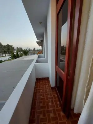 a door to a balcony with a view of the street at El Capricho Paracas in Paracas