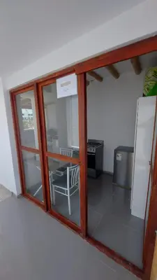 a room with a window with a chair and a refrigerator at El Capricho Paracas in Paracas