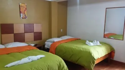 two beds in a room with green and orange at Tierra del Inka in Cusco