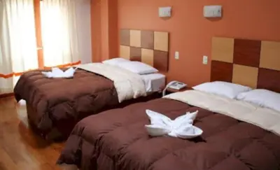 a hotel room with two beds with towels on them at Tierra del Inka in Cusco