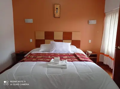 a bedroom with a large bed with a towel on it at Tierra del Inka in Cusco