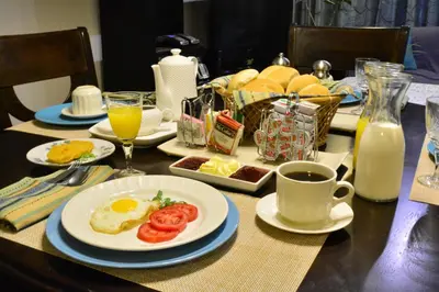 a table with a plate of eggs and a cup of coffee at Kangaroo Wasi Airport Bed & Breakfast in Lima