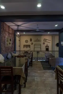 a restaurant with tables and chairs and a brick wall at Desert Nights Hostel in Ica