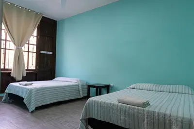 a bedroom with two beds and a blue wall at Desert Nights Hostel in Ica