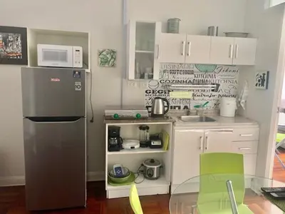 a small kitchen with a refrigerator and a table and chairs at Lindos Apartamentos en San Isidro in Lima
