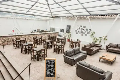 a room with couches and tables and a bar at Hotel Casa Fierro Cusco in Cusco