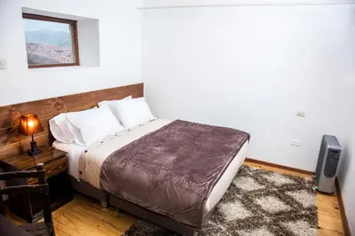 a bedroom with a bed and a desk with a television at Hotel Casa Fierro Cusco in Cusco