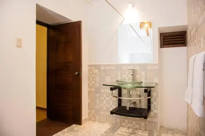 a bathroom with a glass sink and a window at Hotel Casa Fierro Cusco in Cusco