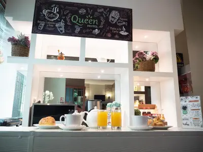 a counter with cups and plates of food and orange juice at Hotel Queen in Lima