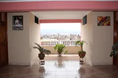 a room with potted plants and a large window at Hotel Mi Casa in Ayacucho