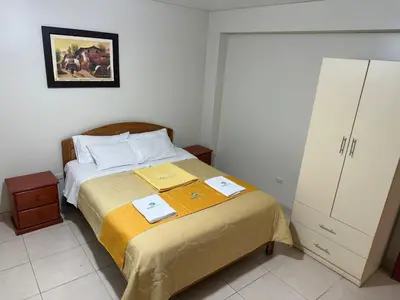 a bedroom with a bed and a cabinet at Illari Wari l - Hotel Sauna in Ayacucho