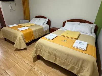 two beds sitting next to each other in a room at Illari Wari l - Hotel Sauna in Ayacucho