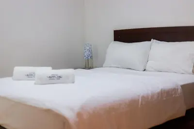 a white bed with two towels on top of it at Hotel Venture in Chincha Alta