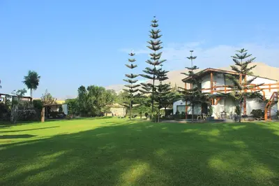a large green yard with a house and trees at Villas de Cieneguilla in Cieneguilla