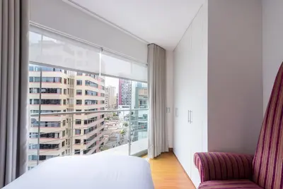 a bedroom with a bed and a large window at InkaHuset Miraflores Deluxe in Lima