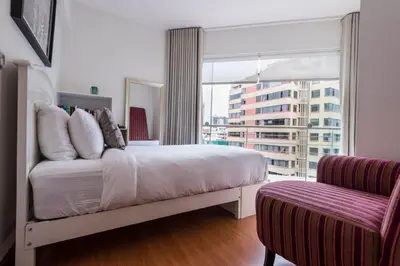 a bedroom with a bed and a large window at InkaHuset Miraflores Deluxe in Lima