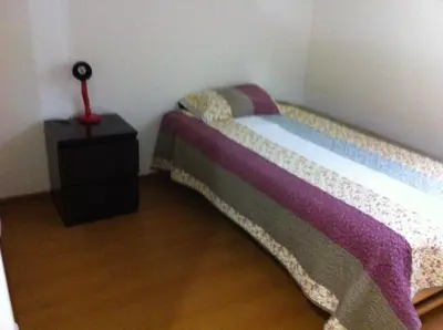 a small bedroom with a bed and a night stand at Departamento Miraflores in Lima