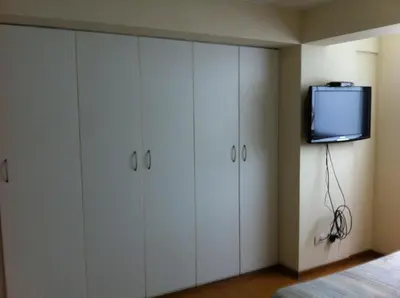 a bedroom with white cabinets and a tv on the wall at Departamento Miraflores in Lima
