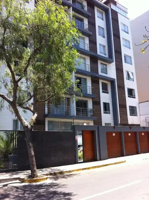 a building with a tree in front of it at Departamento Miraflores in Lima