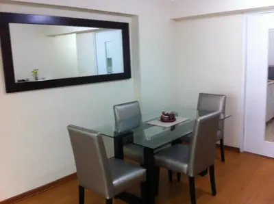 a dining room table with chairs and a mirror at Departamento Miraflores in Lima