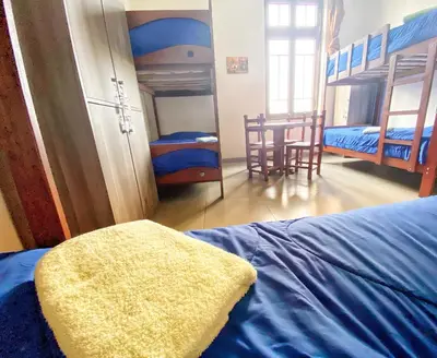 a bedroom with a bed and a room with two bunk beds at Lima House Hostel in Lima