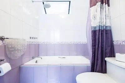 a bathroom with a tub and a toilet and a shower at InkaHuset Airport in Lima
