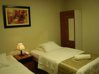 a bedroom with two beds and a lamp on a table at PiscoMar Peru in Pisco