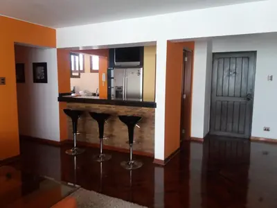 a kitchen with a counter and stools in a room at Miraflores in Lima