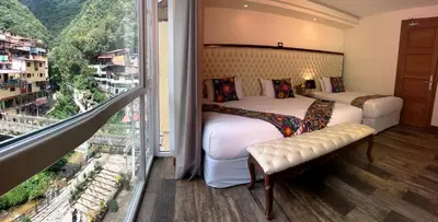 a bedroom with two beds and a large window at Jaya Machu Picchu Boutique Hotel in Machu Picchu