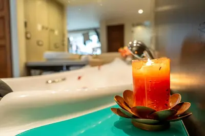a candle sitting on a table next to a bath tub at Jaya Machu Picchu Boutique Hotel in Machu Picchu