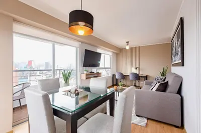 a dining room and living room with a table and chairs at ALU Apartments - Limit with Miraflores Panoramic City View in Lima