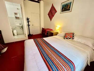 a bedroom with a bed with a colorful blanket on it at Killari B&B in Ollantaytambo