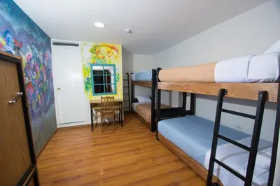 a dorm room with two bunk beds and a hallway at Hommam in Cusco