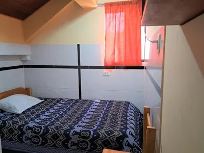 a bedroom with a bed and a red window at Hostal Kuntur Cusco in Cusco