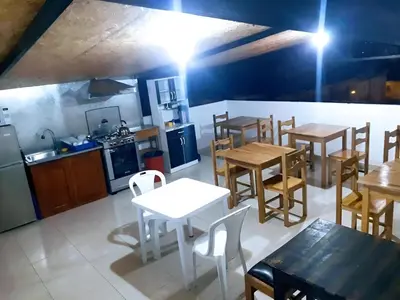a room with tables and chairs and a kitchen at Hostal Kuntur Cusco in Cusco