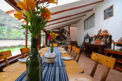 a long wooden table with vases of flowers on it at Casita Huaran in Calca