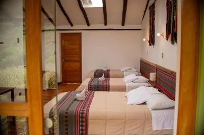 a bedroom with three beds in a room at Casita Huaran in Calca
