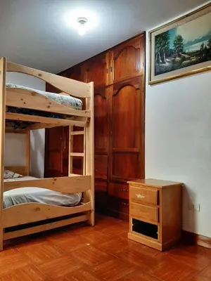 a bedroom with two bunk beds and a desk at Hostal Don Cristobal in Ayacucho