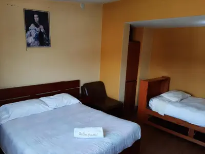 a hotel room with two beds and a picture on the wall at Hostal Don Cristobal in Ayacucho