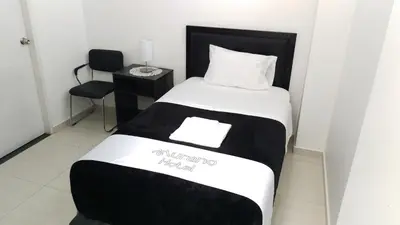 a bedroom with a bed with a black and white comforter at Hotel Murano in Abancay