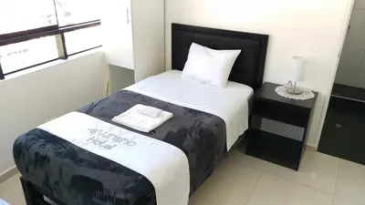 a bedroom with a bed with a black and white comforter at Hotel Murano in Abancay