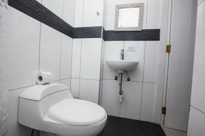 a white bathroom with a toilet and a sink at Hotel Murano in Abancay
