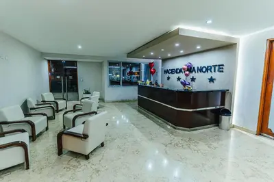 a large lobby with a waiting area with chairs and a bar at Hotel Hacienda Lima Norte in Lima