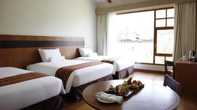a hotel room with two beds and a table with a plate of fruit at Taypikala Deluxe Valle Sagrado in Urubamba