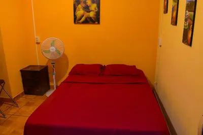 a red bed in a room with a fan at Passion Hostel - Barranco in Lima