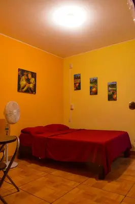 a bedroom with two beds in a yellow room at Passion Hostel - Barranco in Lima