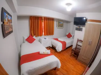 a hotel room with two beds and a television at Machu Picchu Land in Machu Picchu