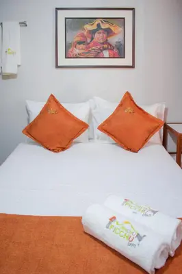 a white bed with two towels on top of it at Machu Picchu Land in Machu Picchu