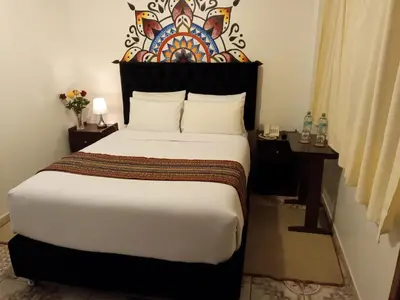 a bedroom with a large bed with a decorative headboard at Inkas Land in Machu Picchu
